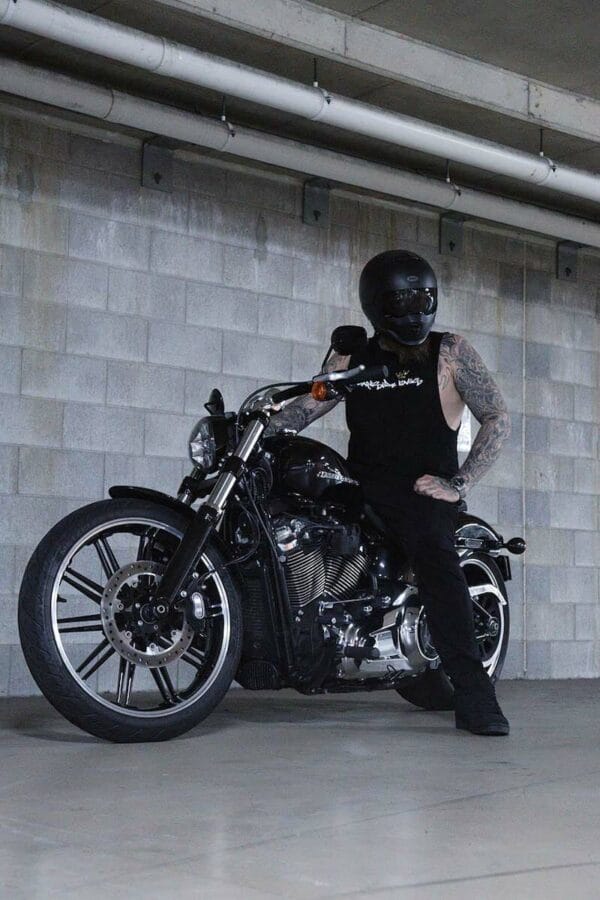 Front view of a male sitting on a motorcycle wearing a DSK Singlet