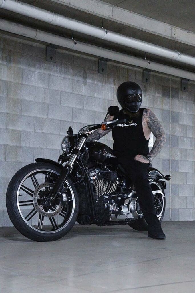 Front view of a male sitting on a motorcycle wearing a DSK Singlet