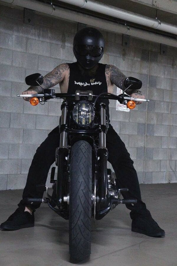 Front view of a male sitting on a motorcycle wearing a DSK Singlet