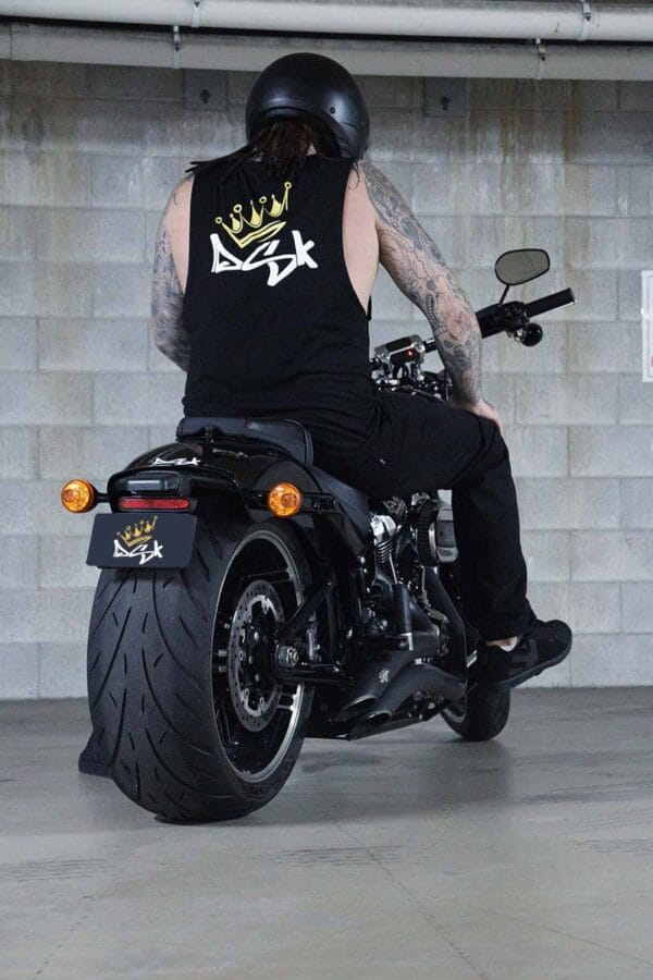 Back view of a male sitting on a motorcycle wearing a DSK Singlet