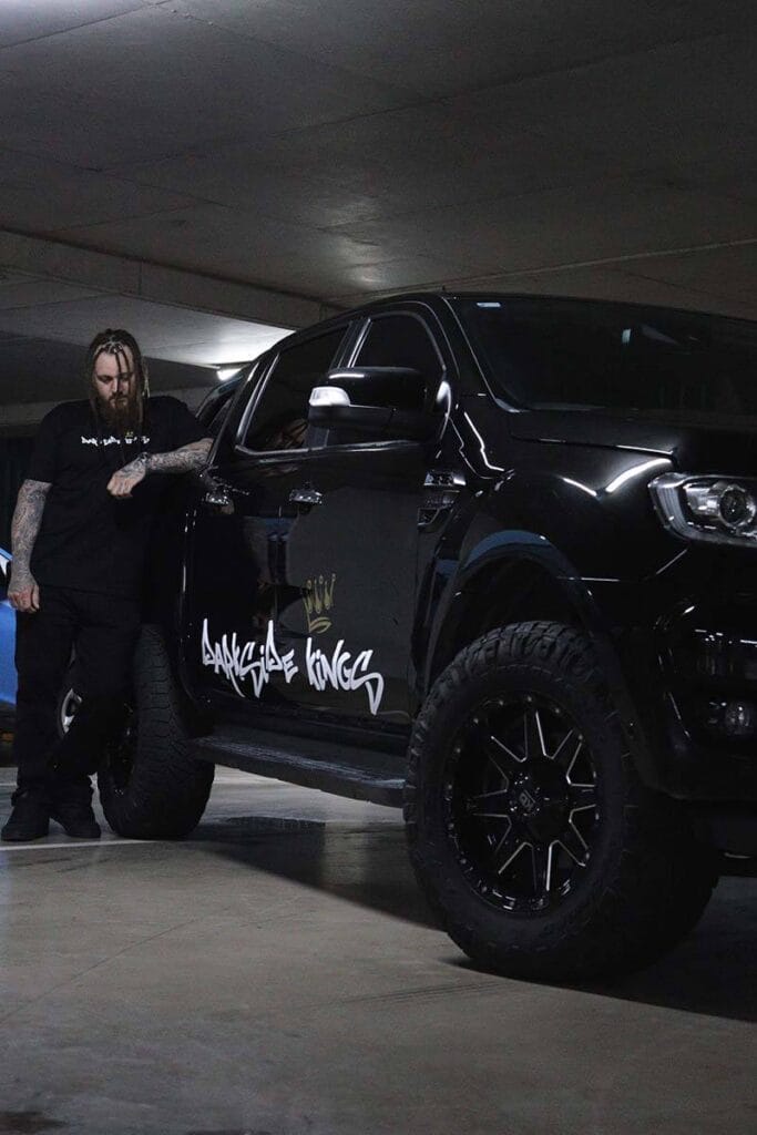 Male wearing a DSK T-shirt leaning against a Ford Ranger