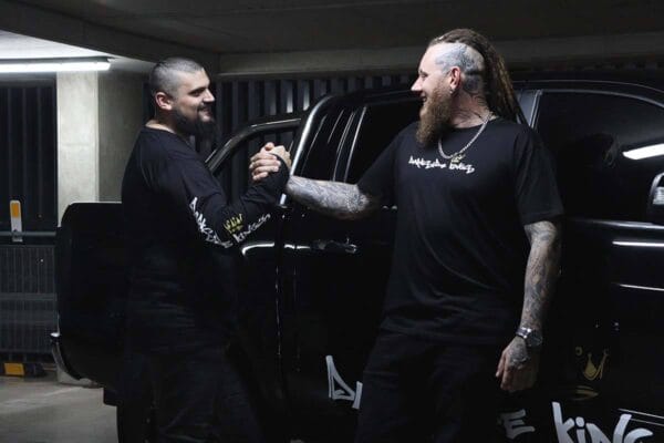 Male wearing a long sleeve DSK shirt and a male wearing a DSK T-shirt shaking hands