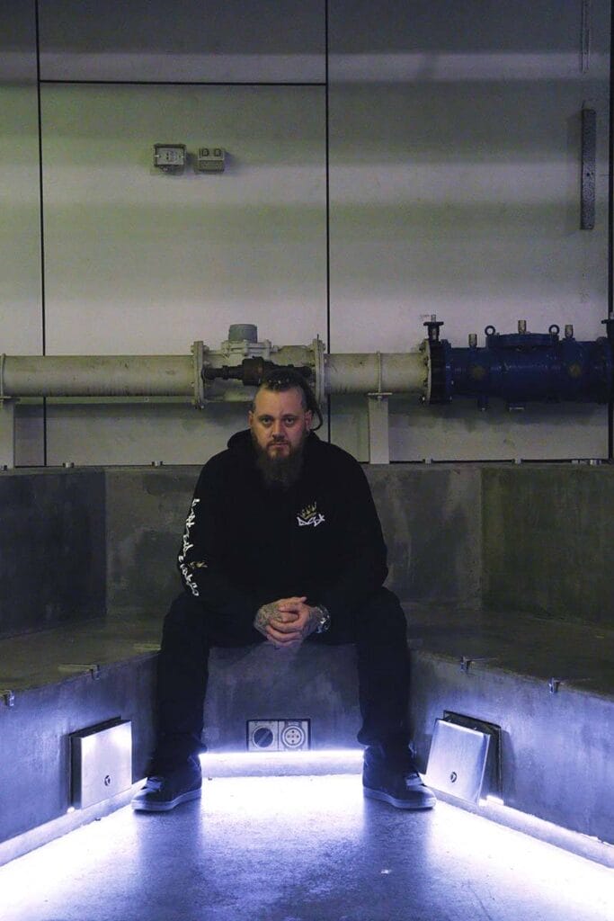 Male wearing a DSK Hoodie sitting on concrete bench