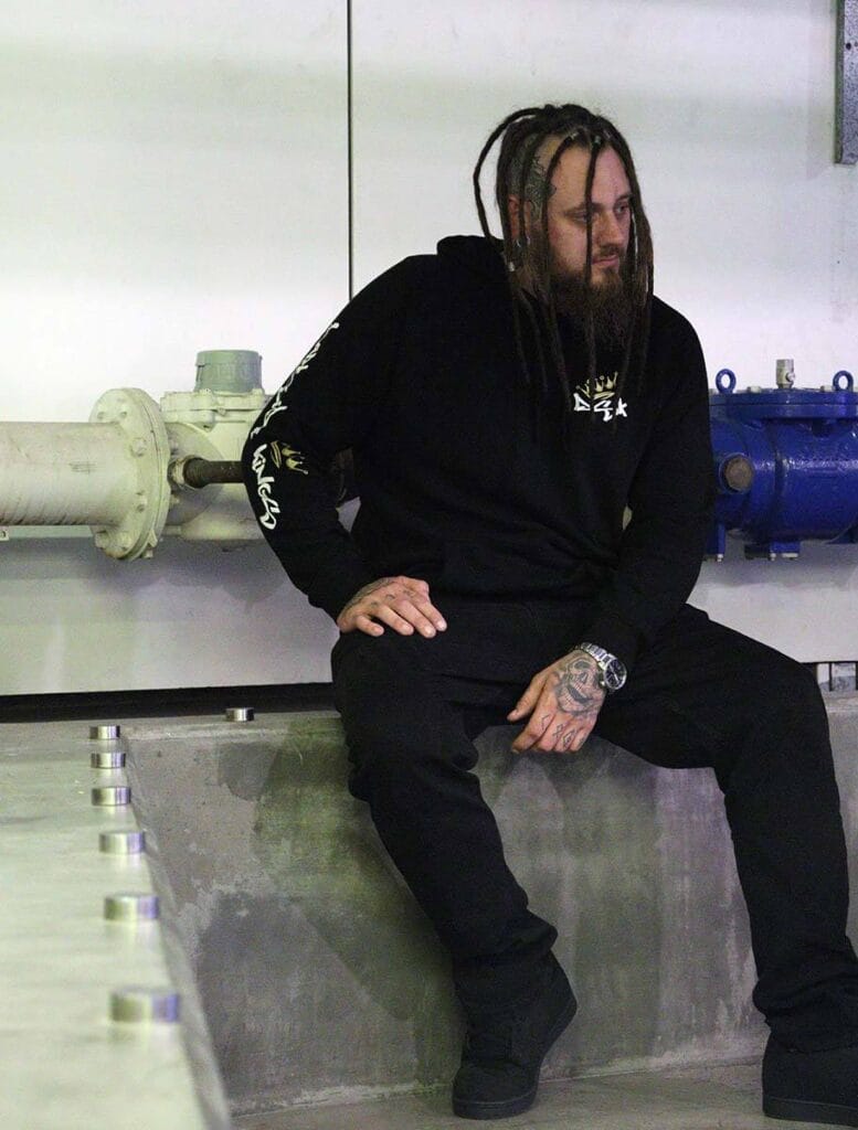 Male wearing a DSK Hoodie sitting on concrete bench