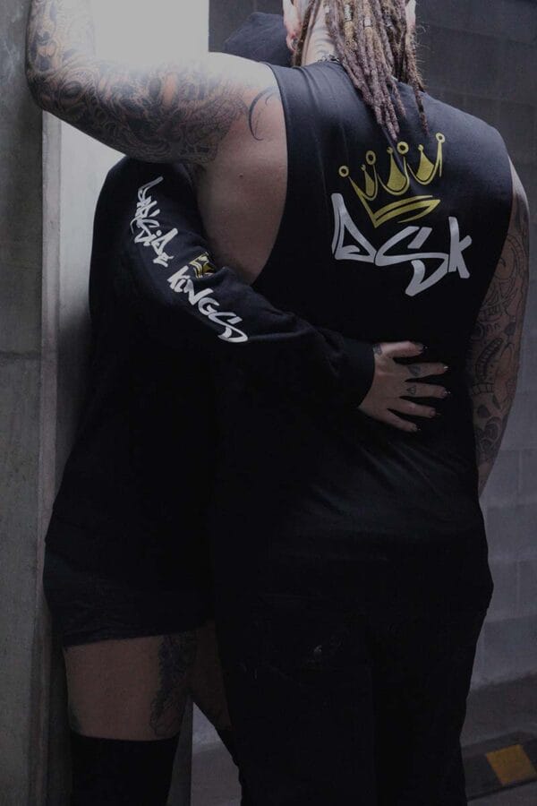 Female wearing a DSK Hoodie hugging a male wearing a DSK Singlet