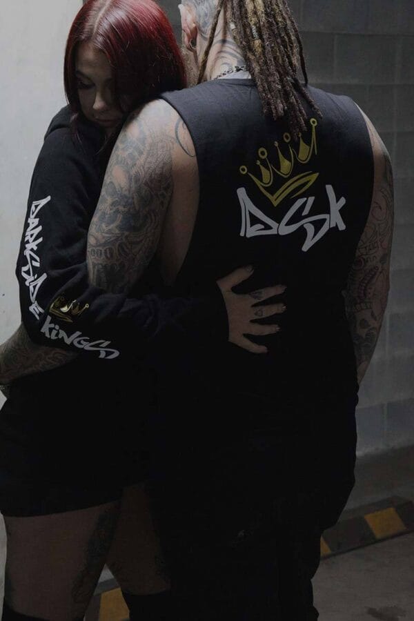 Female wearing a DSK Hoodie hugging a male wearing a DSK Singlet
