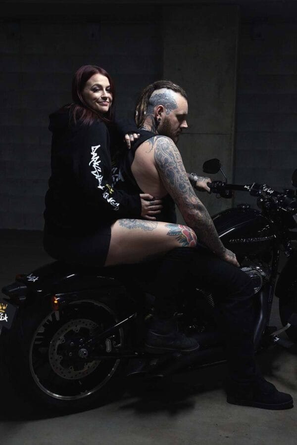 Male wearing a DSK Singlet and female wearing a DSK Hoodie on a motorcycle