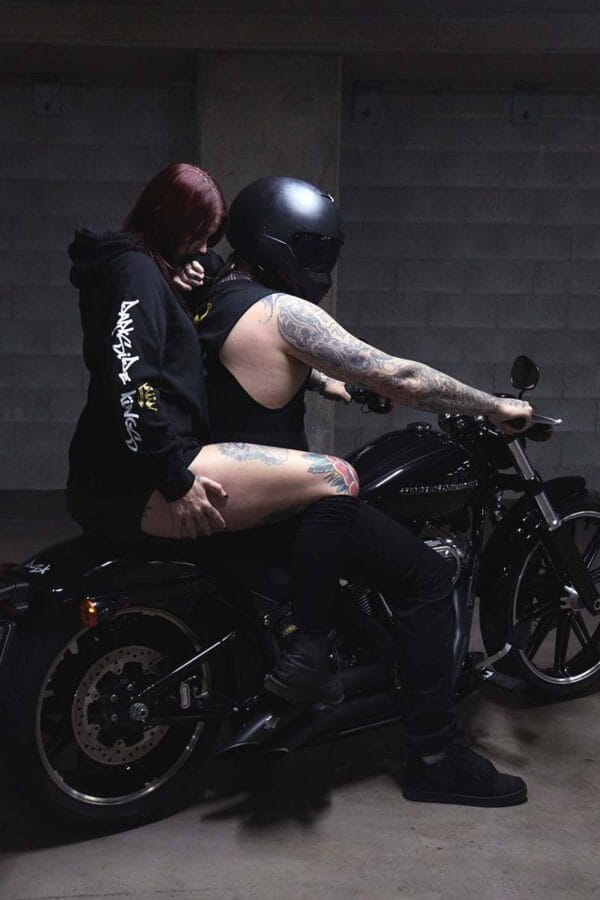 Male wearing a DSK Singlet and female wearing a DSK Hoodie on a motorcycle