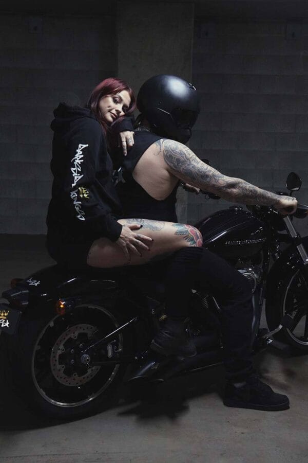 Male wearing a DSK Singlet and female wearing a DSK Hoodie on a motorcycle
