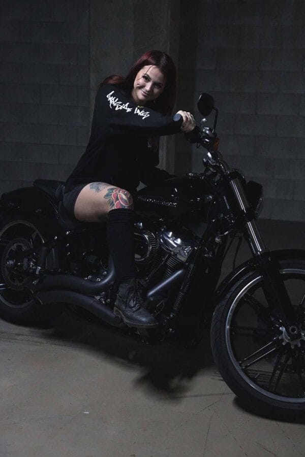 Female sitting on a motorcycle wearing a DSK Hoodie