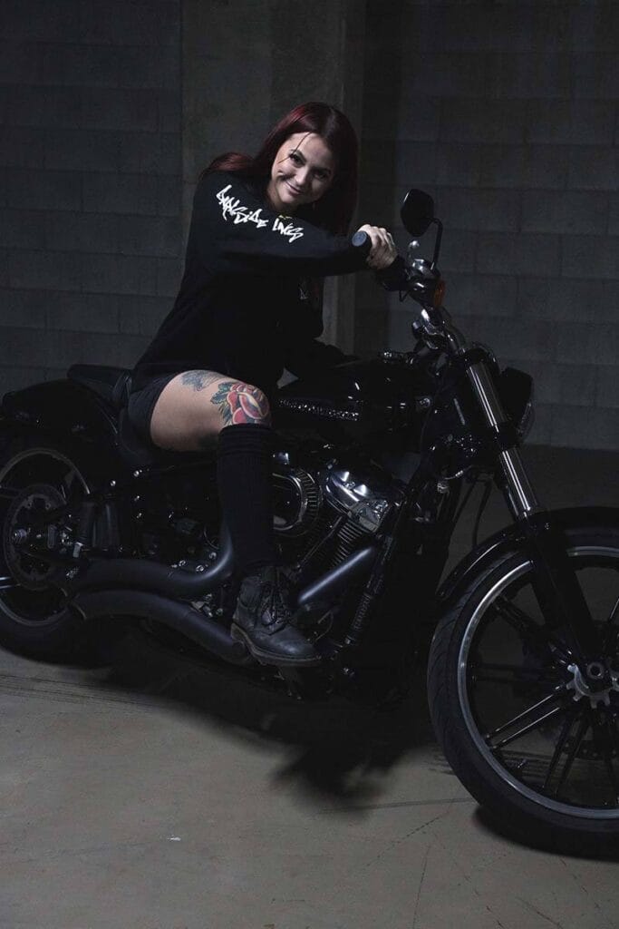 Female sitting on a motorcycle wearing a DSK Hoodie