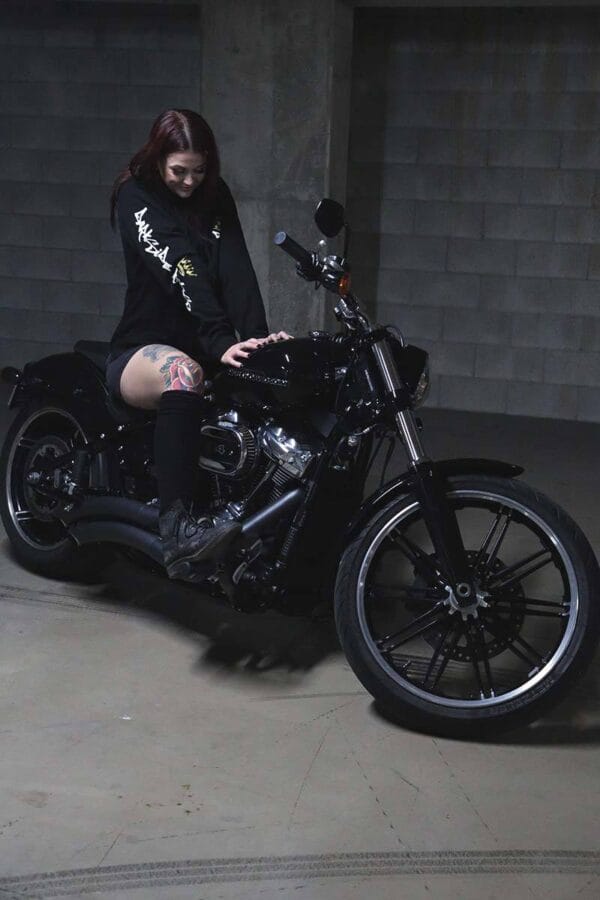 Female sitting on a motorcycle wearing a DSK Hoodie
