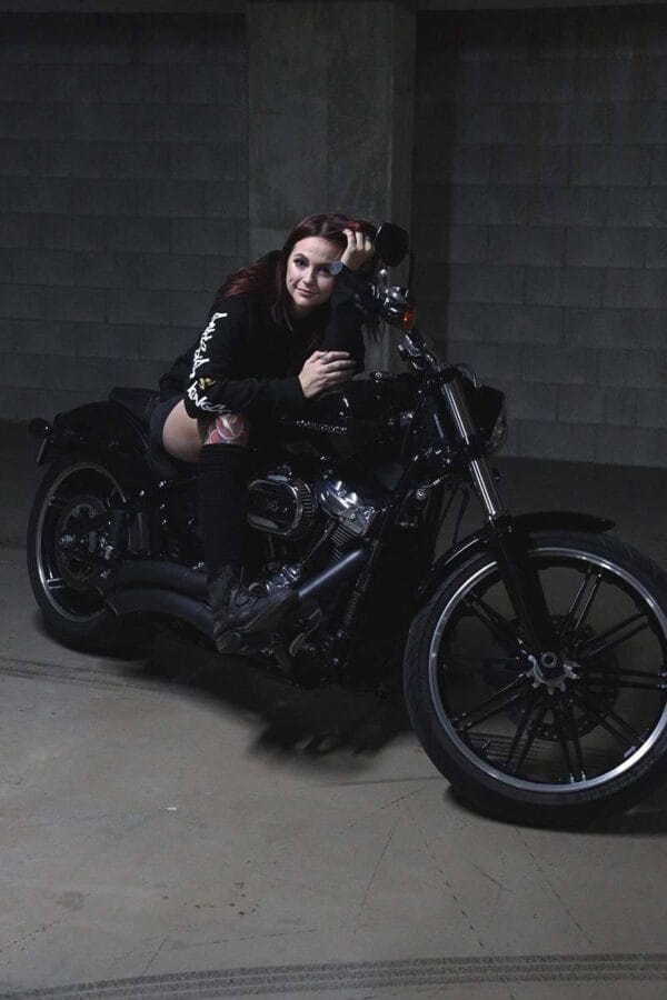 Female sitting on a motorcycle wearing a DSK Hoodie