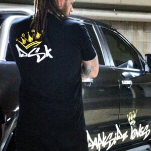 Male wearing a DSK t-shirt standing next to a Ford Ranger