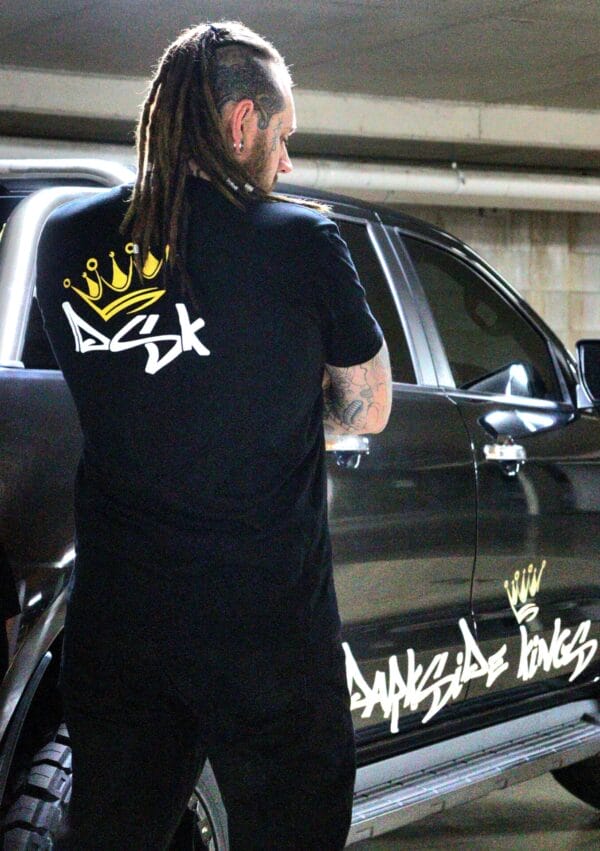 Male wearing a DSK t-shirt standing next to a Ford Ranger