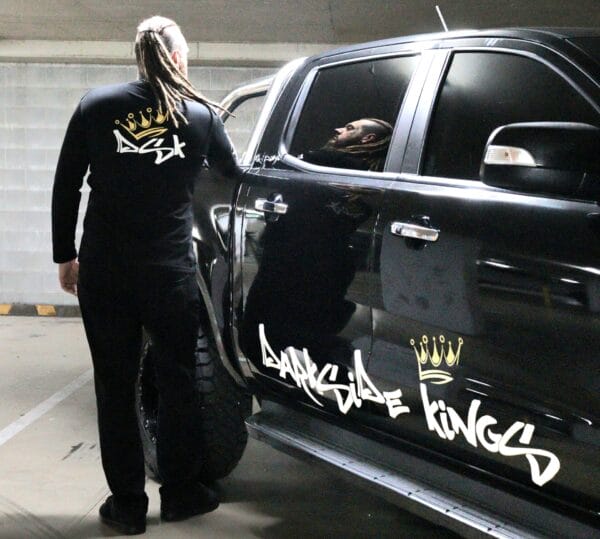 Male wearing a long sleeve DSK shirt standing next to a Ford Ranger