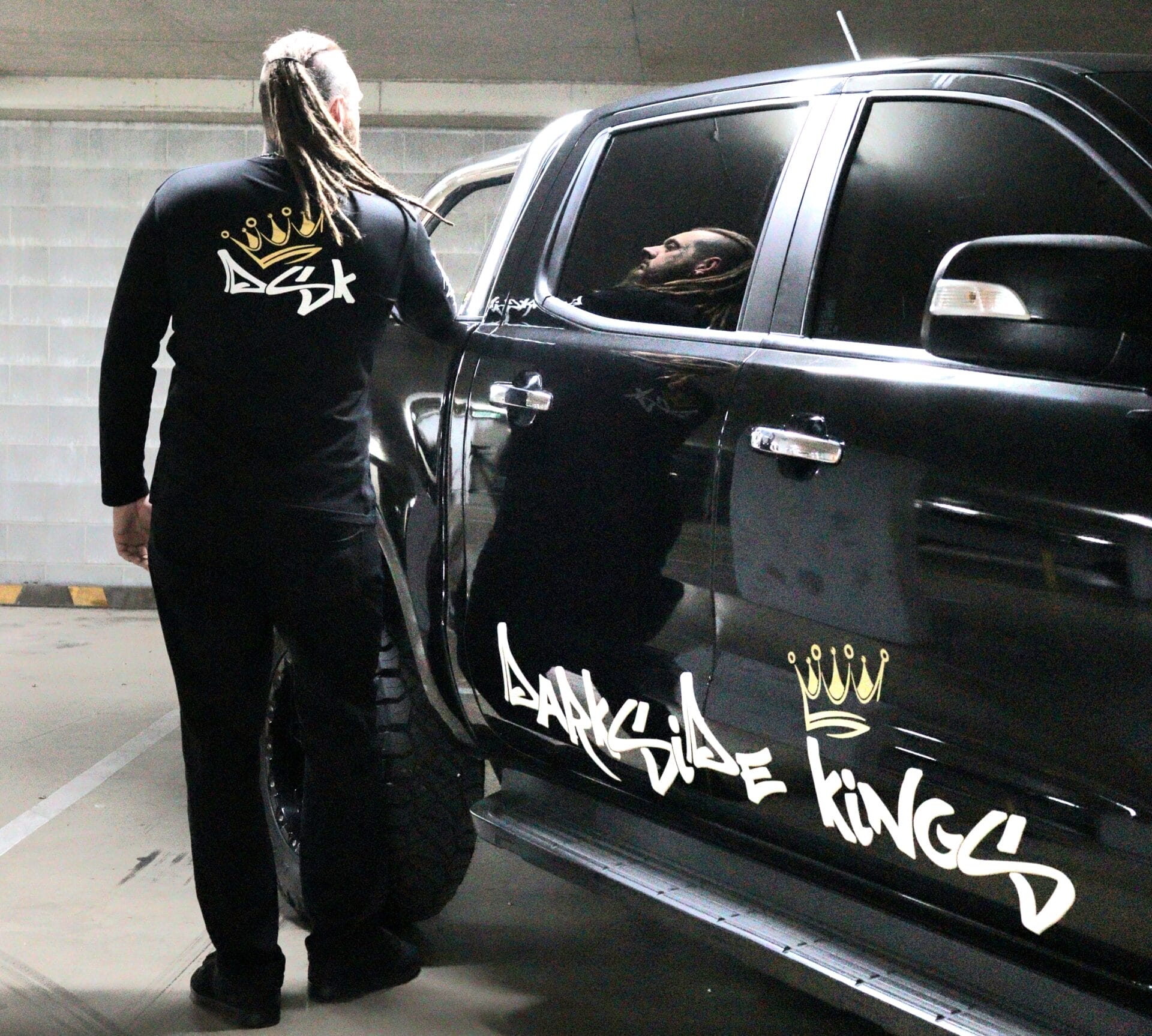 Male wearing a long sleeve DSK shirt standing next to a Ford Ranger