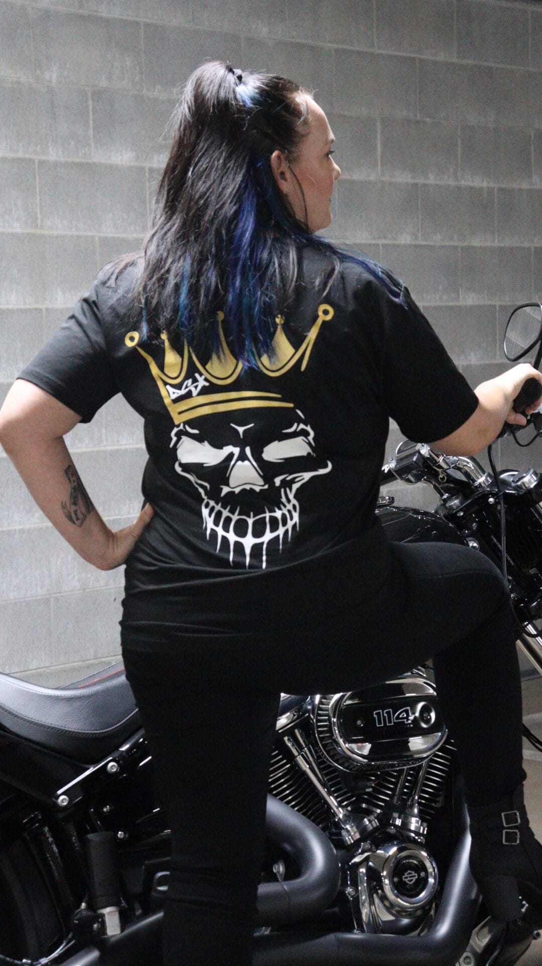 Female wearing a DSK Limited Edition t-shirt standing next to a Harley Davidson Breakout Motorcycle