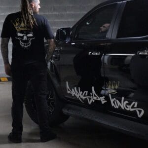 Male wearing a DSK Limited Edition t-shirt standing next to a Ford Ranger