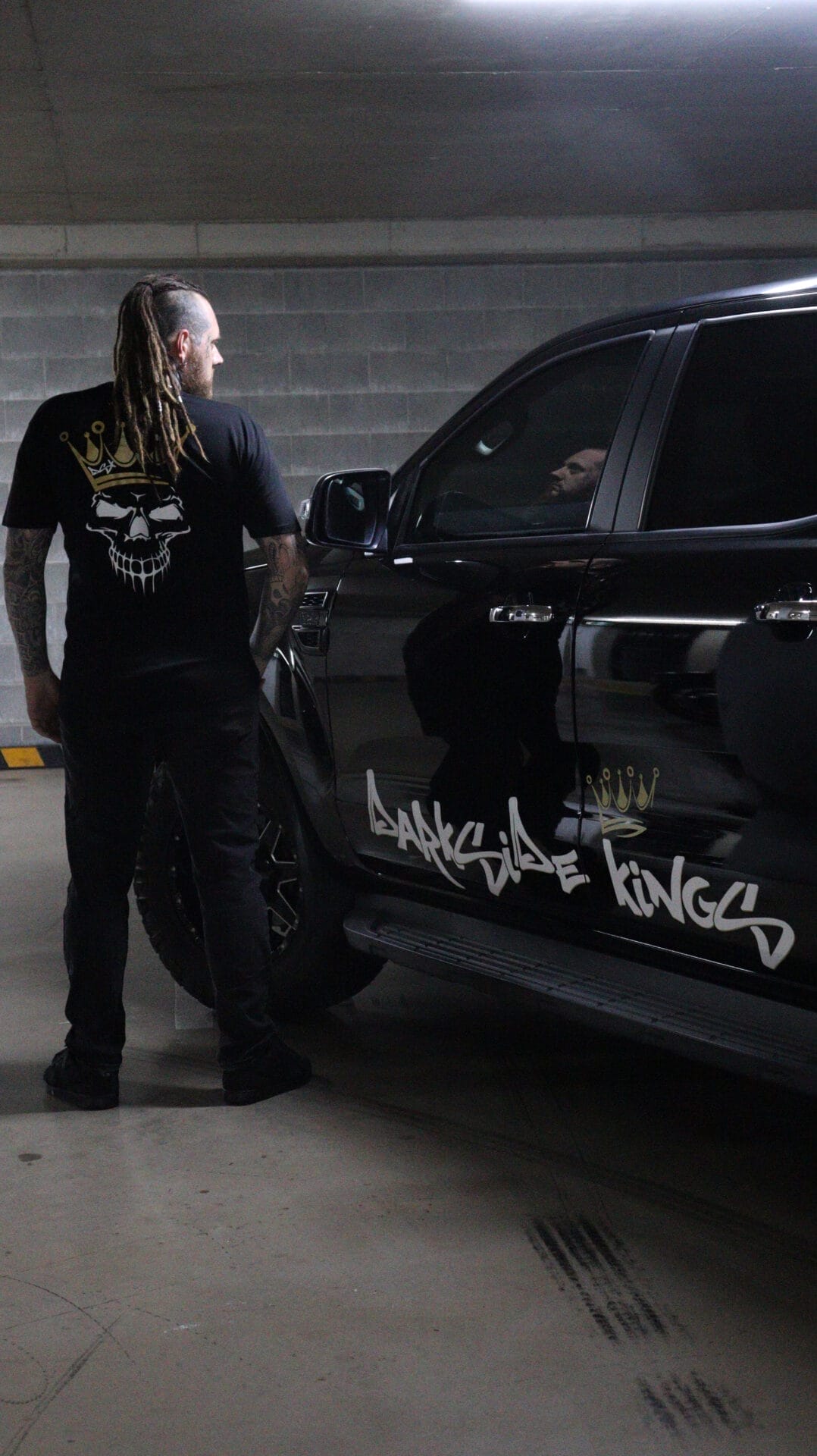 Male wearing a DSK Limited Edition t-shirt standing next to a Ford Ranger